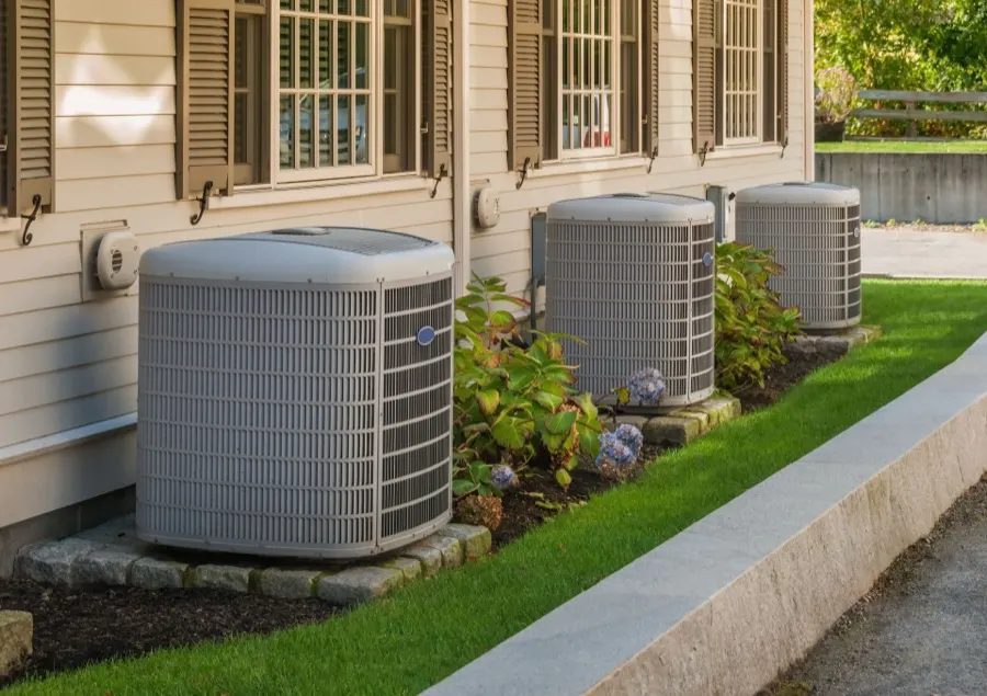 Residential heat pump condensers beside a home